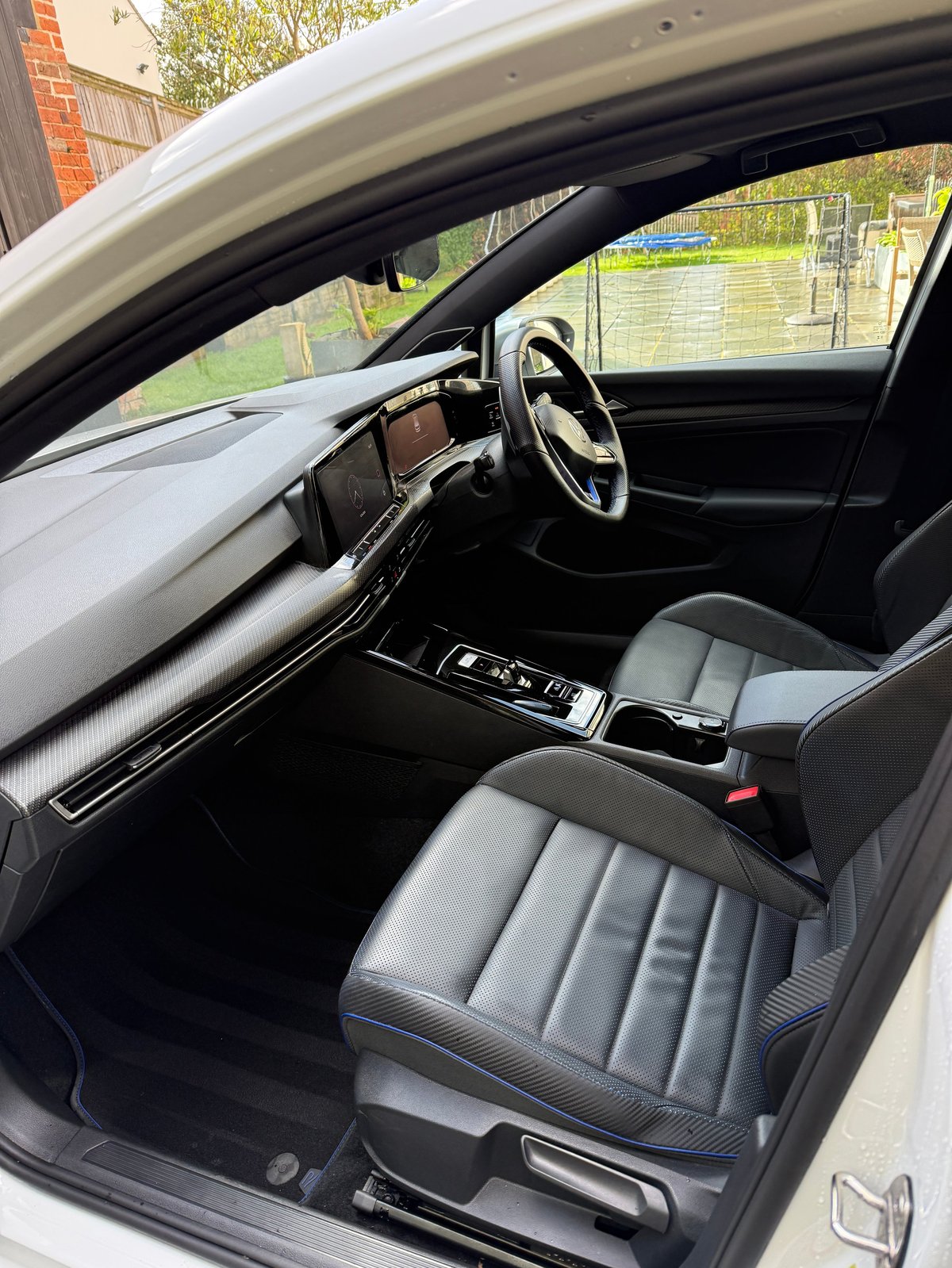 Interior view of modern car with steering wheel, dashboard, and black and gray leather seats